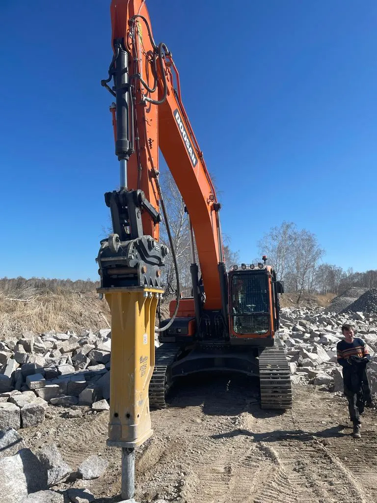 Гусеничный экскаватор Doosan с гидромолотом на каменистой площадке