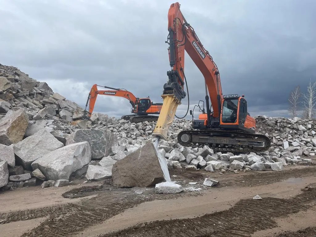 Гусеничные экскаваторы Doosan с гидромолотом разбивают скальную породу