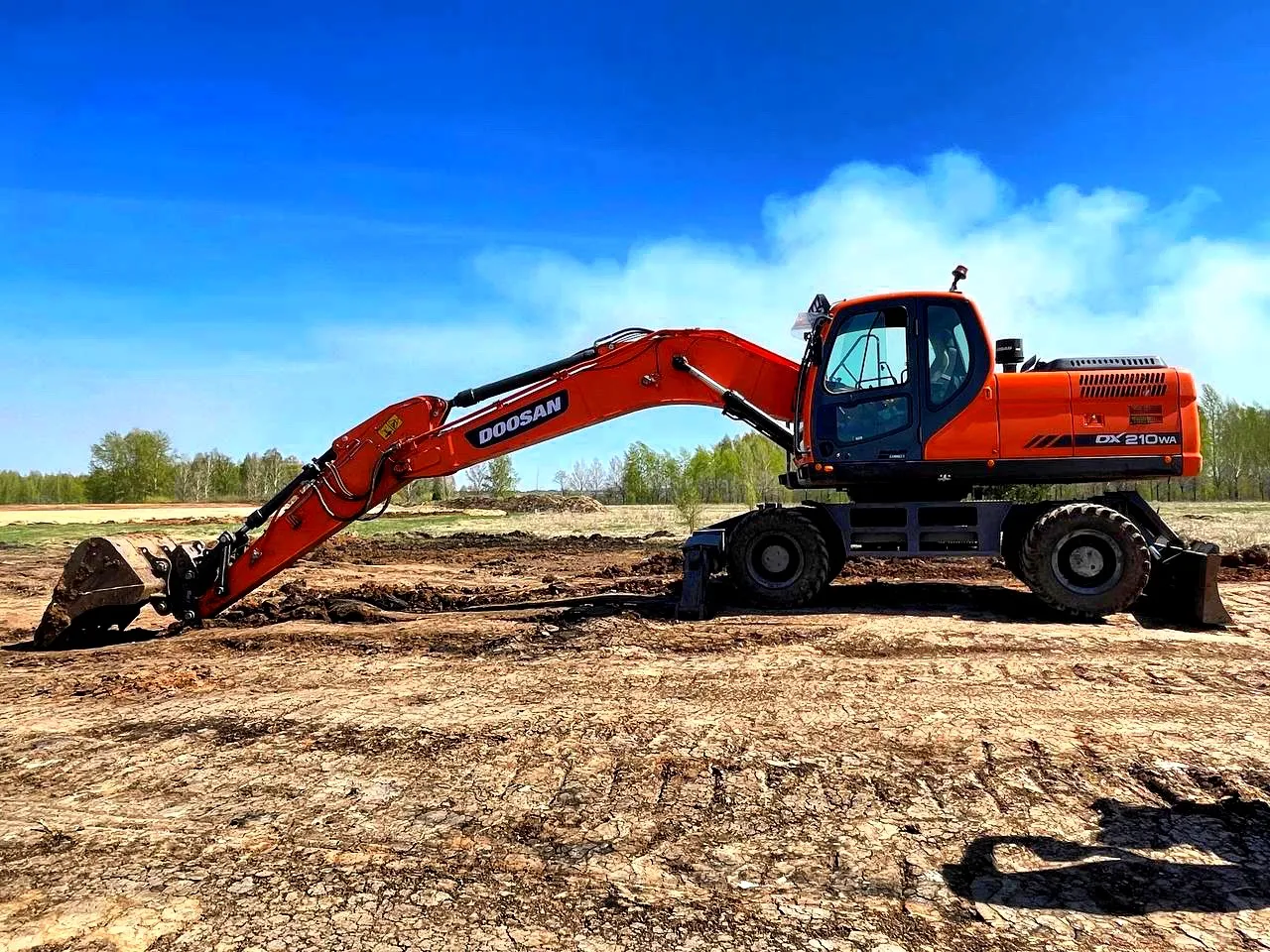 Колёсный экскаватор Doosan DX210WA на планировке участка
