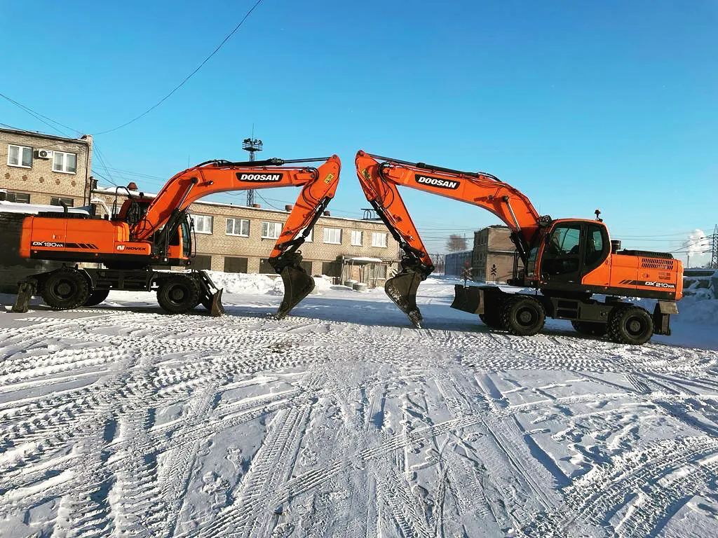 Два колёсных экскаватора Doosan на заснеженной площадке